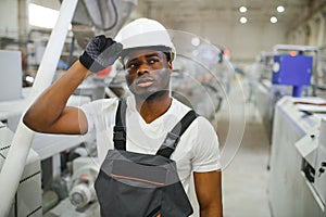 Industrial worker indoors in factory. Young technician with white hard hat
