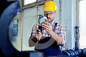 Industrial worker inspector measuring detail with Vernier Caliper