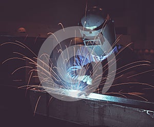 Industrial Worker laborer at the factory welding steel