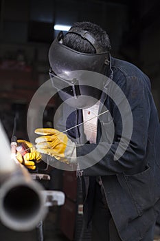 Industrial Worker labourer at the factory welding steel structure