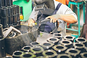 Industrial worker in manufacturing plant grinding to finish a Metal pipe