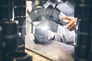 Industrial worker in manufacturing plant grinding to finish a Metal pipe