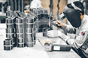 Industrial worker in manufacturing plant grinding to finish a Metal pipe