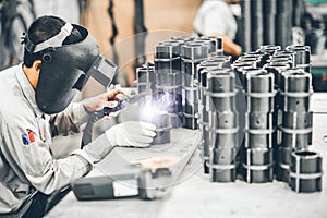 Industrial worker in manufacturing plant grinding to finish a Metal pipe