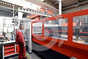 Industrial worker operates a laser cutting machine - employee in