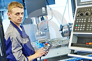 Industrial worker operating cnc milling machine in metal machining industry