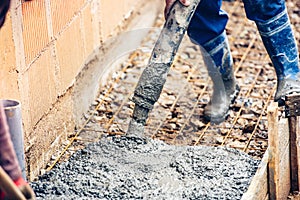 Industrial worker pouring cement or concrete with automatic pump tube