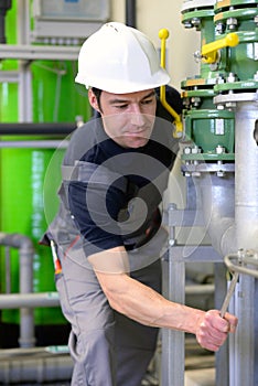 Industrial worker repairs machines and equipment in a refinery