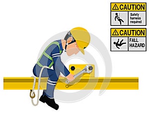 An industrial worker with safety harness is working at height