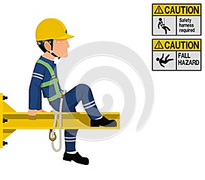 An industrial worker with safety harness is working at height