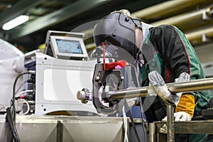 Industrial worker setting orbital welding machine.