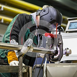 Industrial worker setting orbital welding machine.