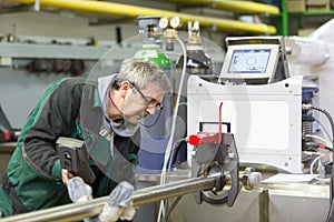 Industrial worker setting orbital welding machine.