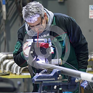 Industrial worker setting orbital welding machine.