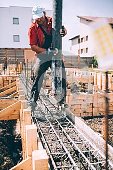 Industrial worker using concrete pump for building house foundation. Details of constuctor on construction site