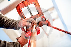 Industrial worker using industrial copper cutter in plumbing