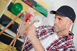 Industrial worker using propane gas torch for soldering copper pipes
