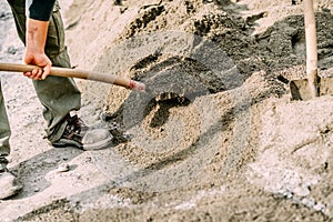 Worker wearing protective gear using shovel on construction site