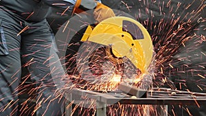 Industrial worker wearing safety gloves cutting steel or welding metal construction with fire at factory. Industrial mechanic engi