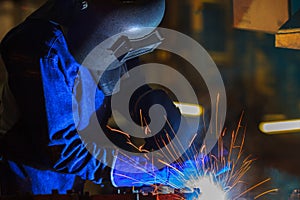 Industrial worker is welding in construction plant