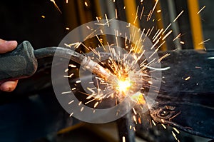 Industrial worker welding metal in steel factory