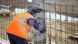 Industrial worker welding of metal structures, welder man male worker soldering steel beam structure on new building on