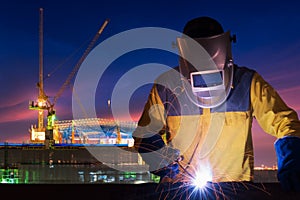 Industrial worker welding steel structure for infrastructure building project