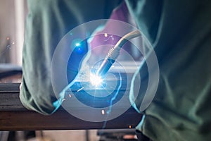 Industrial worker welding the steel structure in the workshop