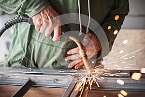Industrial worker welding the steel structure in the workshop