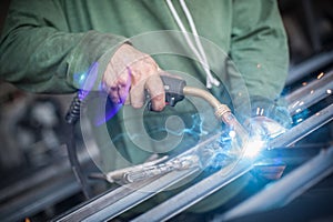 Industrial worker welding the steel structure in the workshop