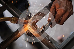 Industrial worker welding the steel structure in the workshop