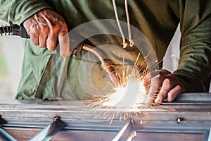 Industrial worker welding the steel structure in the workshop