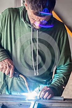 Industrial worker welding the steel structure in the workshop