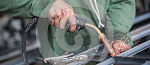 Industrial worker welding the steel structure in the workshop