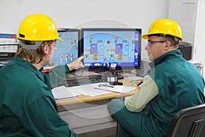 Industrial workers in control room photo