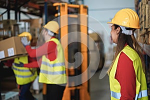 Industrial workers loading delivery boxes inside warehouse store - Focus on woman head