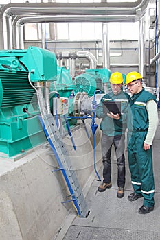 Industrial workers with notebook, teamwork