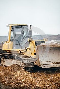 Industrial yellow bulldozer leveling earth