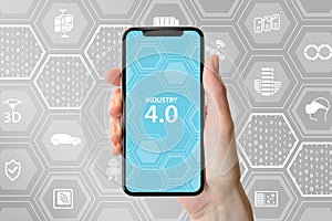 Industry 4.0 text displayed on smartphone screen. Hand holding modern frameless smart phone in front of neutral background