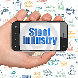 Industry concept: Hand Holding Smartphone with Steel Industry on display