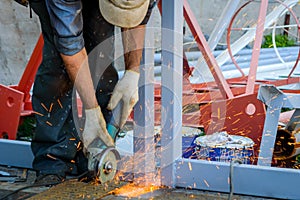A industry construction worker using an angle grinder for cut of metall and producing a lot of sparks