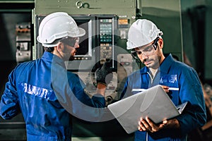 Industry engineer team worker operate control heavy machine with computer laptop to help analysis operating problem