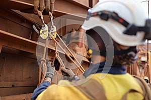 Industry inspector worker wearing a safety protection helmet inspecting, tie, secure stopping knot attached on descender device photo