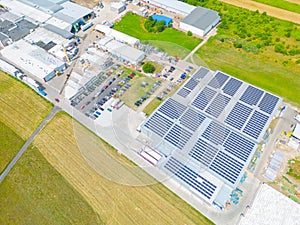 Industry with low carbon footprint. Industrial warehouses with solar panels on the roof. Technology park and factories from above