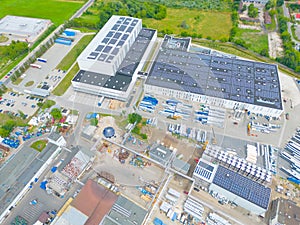 Industry with low carbon footprint. Industrial warehouses with solar panels on the roof. Technology park and factories from above