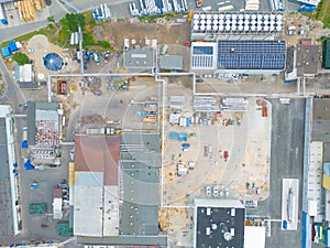 Industry with low carbon footprint. Industrial warehouses with solar panels on the roof. Technology park and factories from above