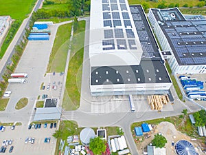 Industry with low carbon footprint. Industrial warehouses with solar panels on the roof. Technology park and factories from above