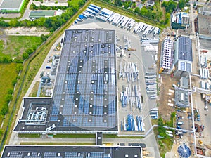 Industry with low carbon footprint. Industrial warehouses with solar panels on the roof. Technology park and factories from above