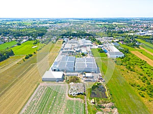 Industry with low carbon footprint. Industrial warehouses with solar panels on the roof. Technology park and factories from above