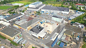 Industry with low carbon footprint. Industrial warehouses with solar panels on the roof. Technology park and factories from above